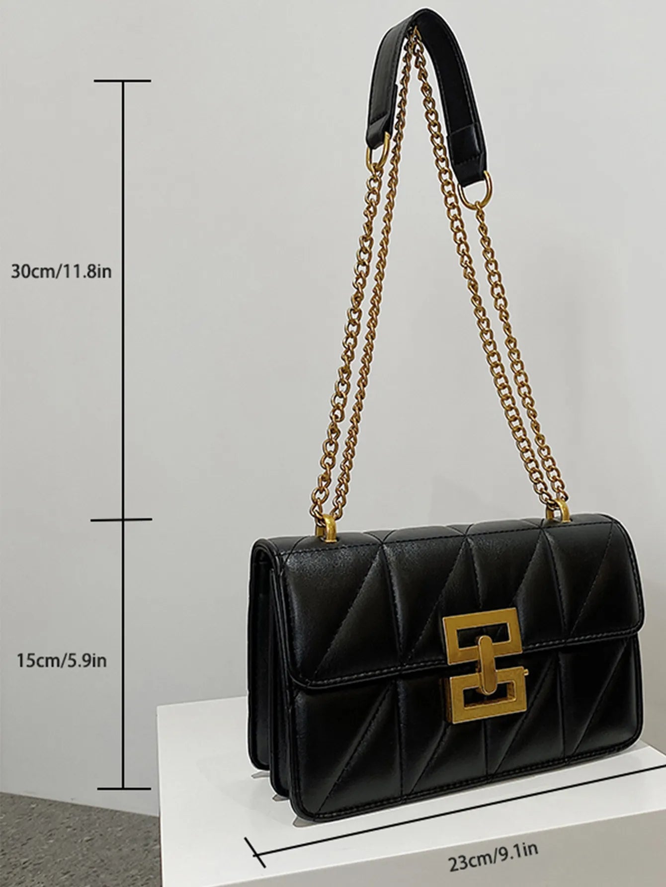 Schwarze Lederhandtasche mit goldener Kette, geometrischem Muster, 23x15x30 cm.