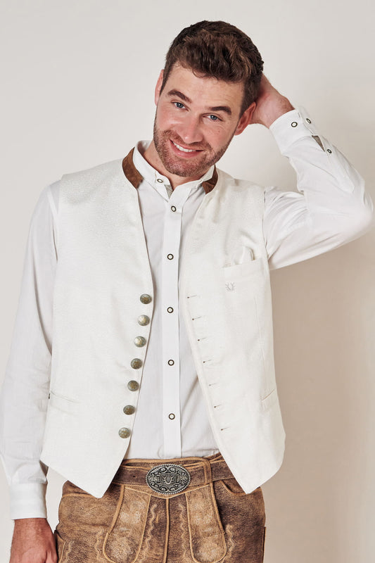 Mann in weißer Trachtenweste und Lederhose, traditionelles bayerisches Outfit, lächelnd.
