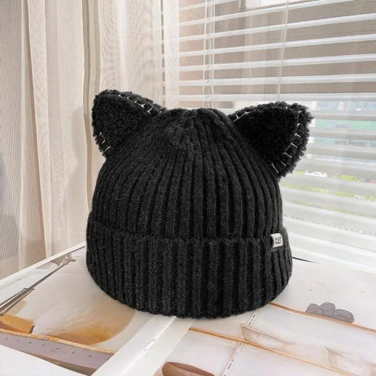 Schwarze Strickmütze mit Katzenohren, modisches Accessoire, warm, gemütlich, Winterkleidung.