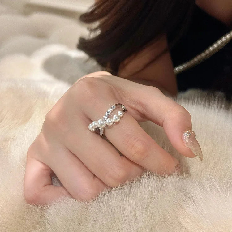 Damenhand mit elegantem Perlenring, Silber, funkelnde Details, luxuriöses Schmuckdesign.