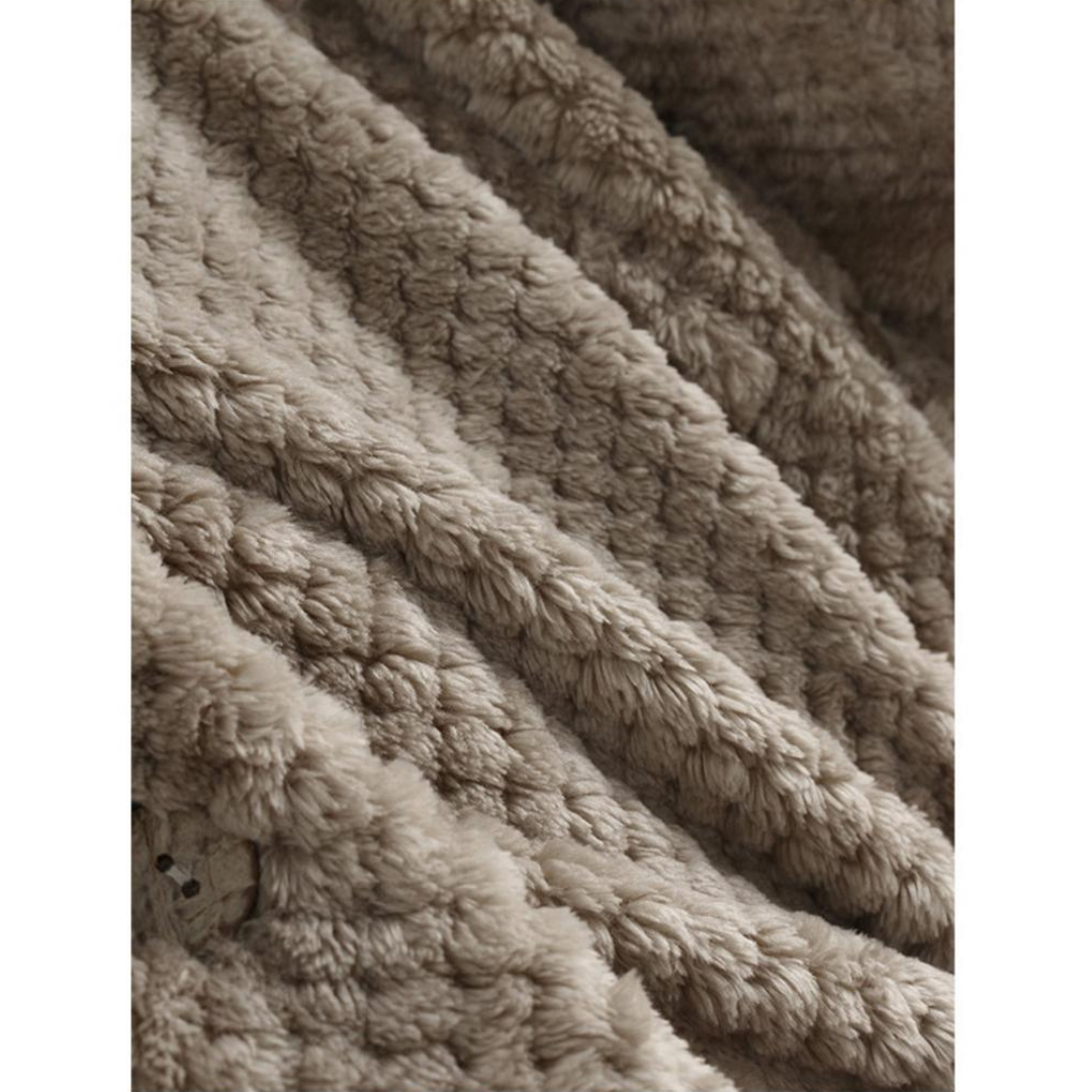 Beige Kuscheldecke aus weichem Plüsch, ideal für gemütliche Abende, warm und flauschig.