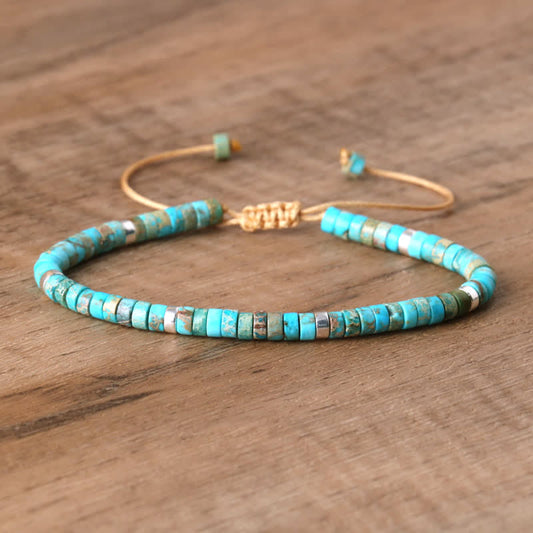 Armband aus türkisfarbenen Perlen, verstellbar, auf Holzoberfläche, handgefertigter Schmuck.