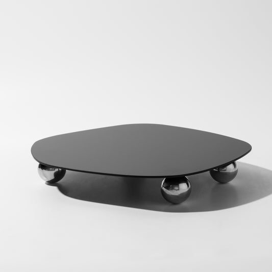 Schwarzer Couchtisch mit runder Platte und kugelförmigen Beinen, modernes Design.