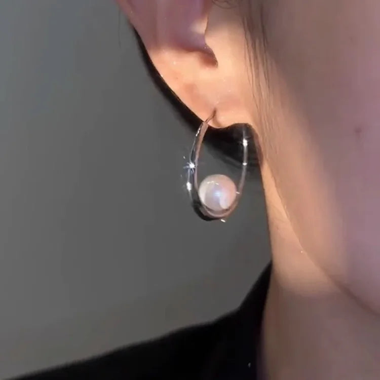 Silberner Ohrring mit Perle, eleganter Schmuck, modisches Accessoire für Damen.
