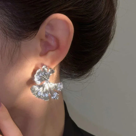 Silberne Ohrringe in Blumenform, glänzend, modisch, Damenaccessoire, Nahaufnahme.