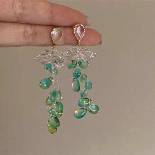 Handgefertigte Ohrringe mit grünen und blauen Perlen, transparentem Blüten-Design, elegant.