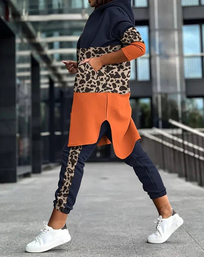 Frau in elegantem Zweiteiler mit Leopardenmuster, Hoodie und Jogginghose, Herbstmode 2023.