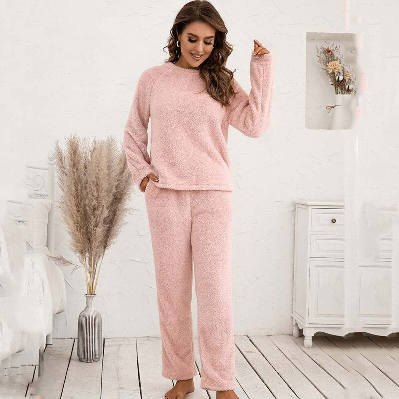 Frau in rosa Fleece-Pyjama-Set, gemütlich, langärmelig, Wohnzimmer, Herbstmode.