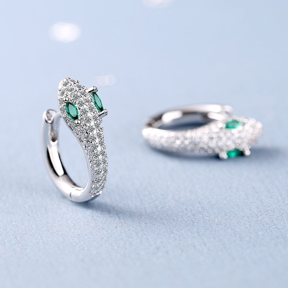 Silberne Schlangen-Ohrringe mit grünen Edelsteinen, funkelnde Zirkonia, eleganter Schmuck.