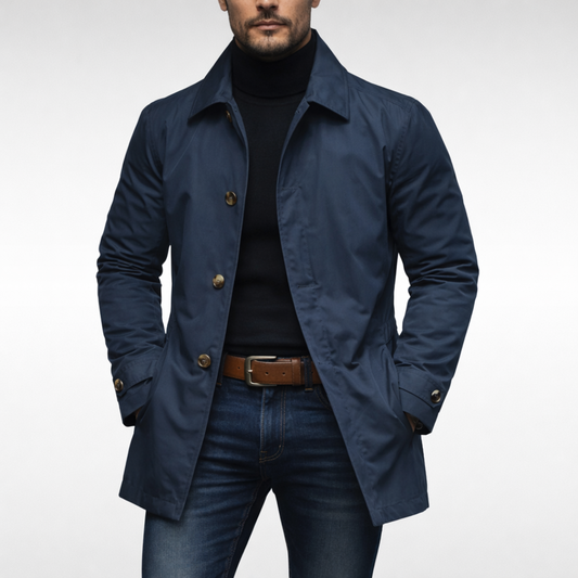 Marinblå trenchjacka med spetsig krage och knappar, buren öppen över svart polotröja och jeans, studiobild framifrån. 2