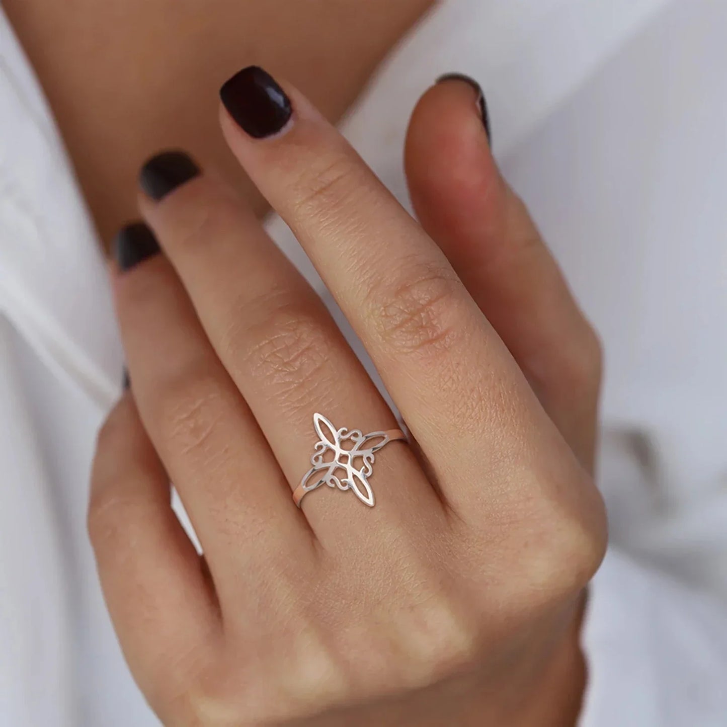 Silberner Schmetterlingsring an Hand, eleganter Schmuck, Damenmode, minimalistisches Design.