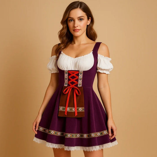 Kvinna i lila dirndl med off-shoulder-blus, röd snörning, brunt förkläde med blommigt band och vit spetskant i kjolfållen. 2