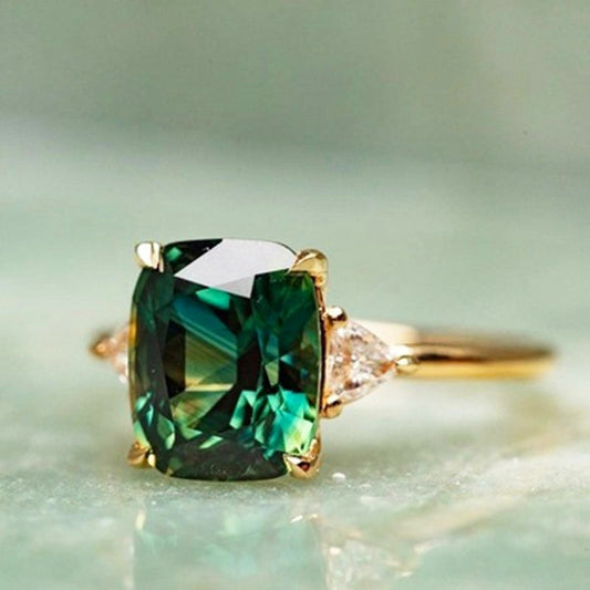 Smaragdgrüner Edelsteinring mit Goldfassung und Diamanten, luxuriöser Schmuck, Nahaufnahme.