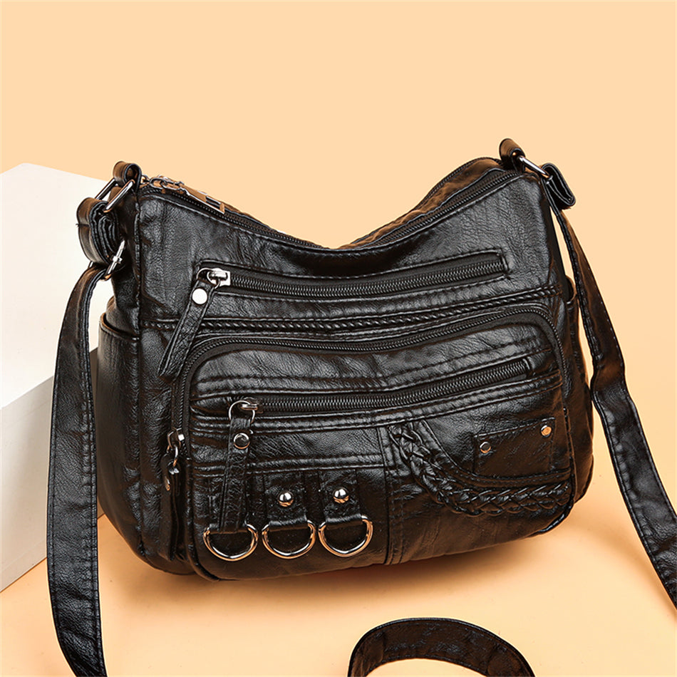 Schwarze Lederhandtasche mit Reißverschlusstaschen und Ringen, modisch und vielseitig.