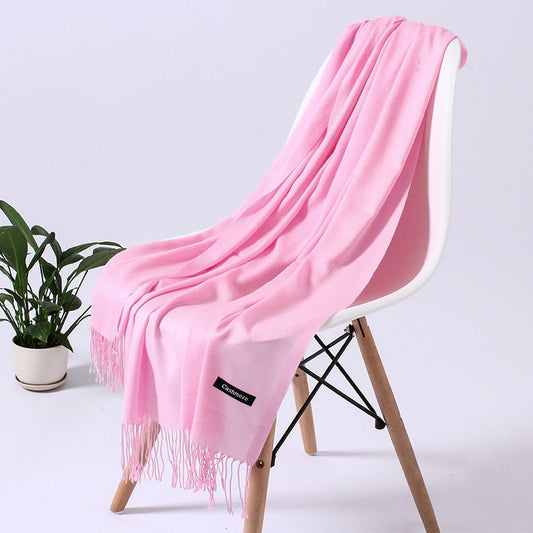 Rosa Kaschmirschal auf weißem Stuhl, weiches Material, modisches Accessoire, Wohnzimmerdekor.