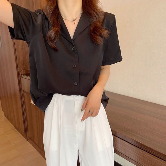 Frau in schwarzer Bluse und weißer Hose, elegante Damenmode, Freizeitkleidung, Sommeroutfit.