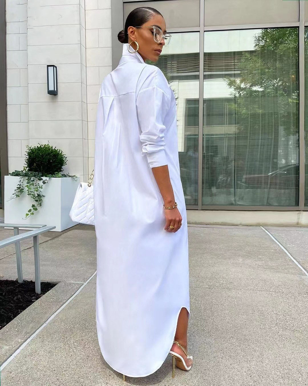 Frau in weißem Hemdkleid, elegantes Design, Sommermode, draußen, moderne Brille, hohe Absätze.