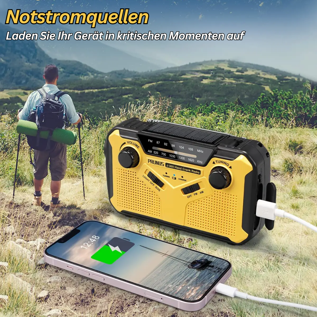 Gelbes Notfallradio mit Solarpanel und Kurbel, lädt Smartphone im Freien auf.