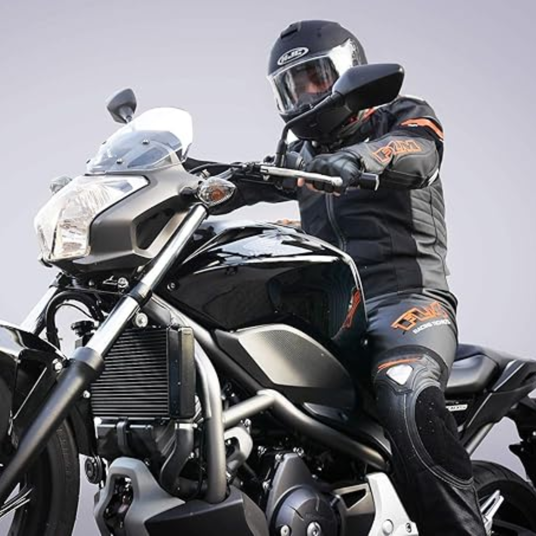 Motorradfahrer in schwarzer Schutzkleidung auf schwarzem Motorrad, Helm, Sicherheitsausrüstung.