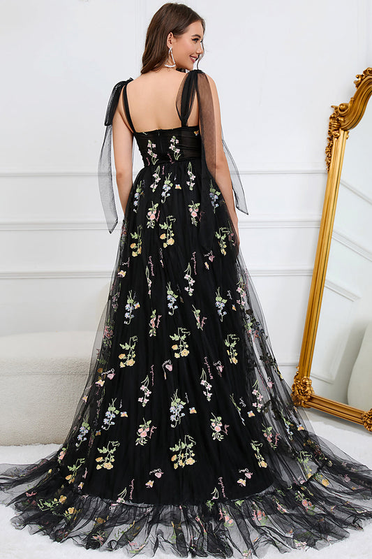 Frau in schwarzem Abendkleid mit Blumenstickerei, elegantes Design, festliche Mode.