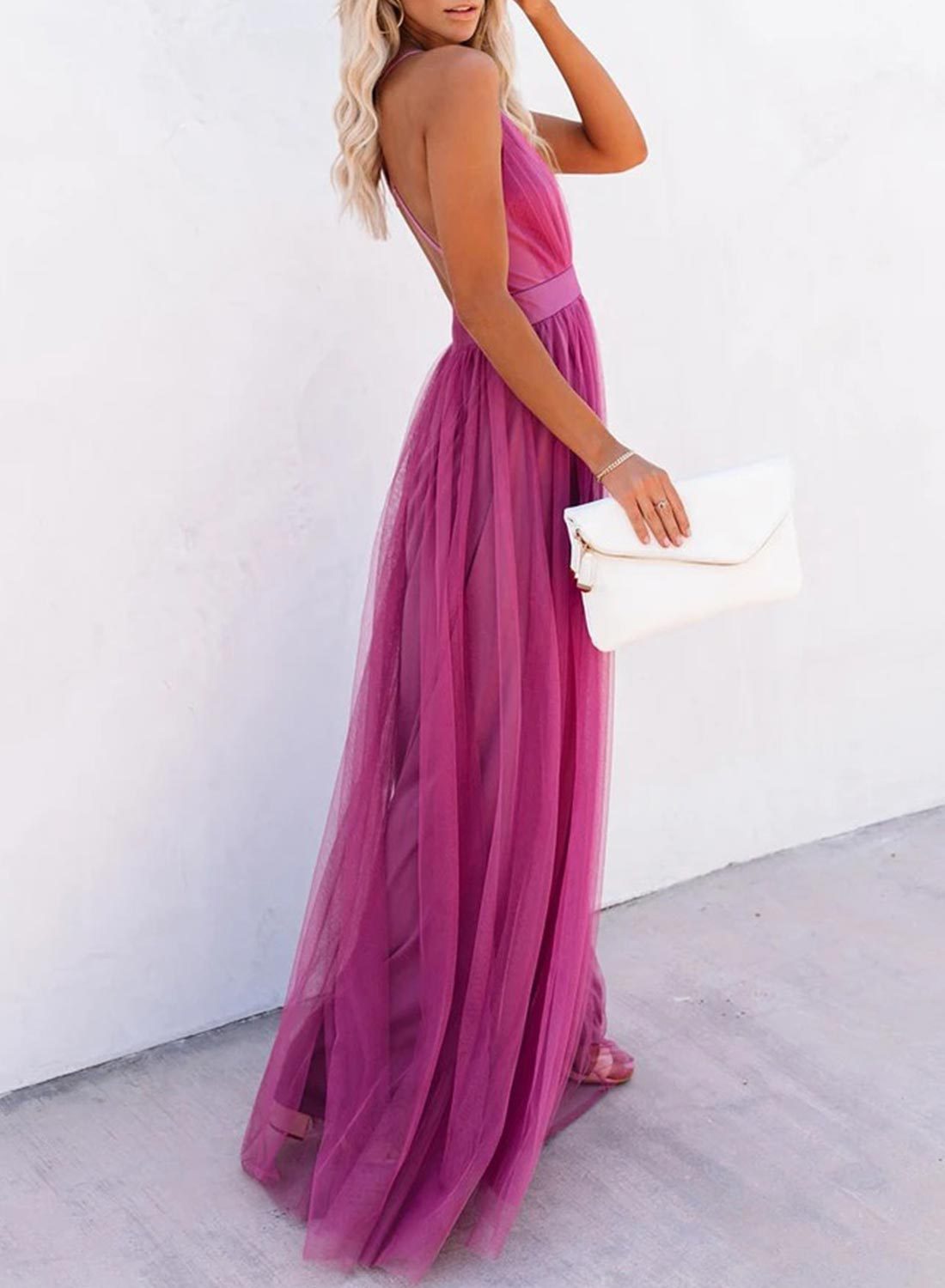 Frau in langem, pinkem Abendkleid aus Tüll mit weißer Clutch, elegantes Outfit für Events.