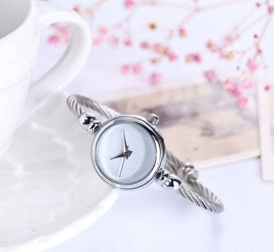 Silberne Damenarmbanduhr mit rundem Zifferblatt, elegantes Design, auf weißem Hintergrund.