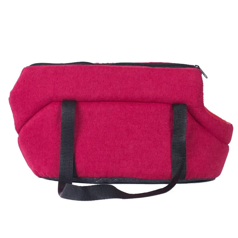 Rote Hundetragetasche aus Stoff mit schwarzen Griffen, ideal für Haustiertransport.