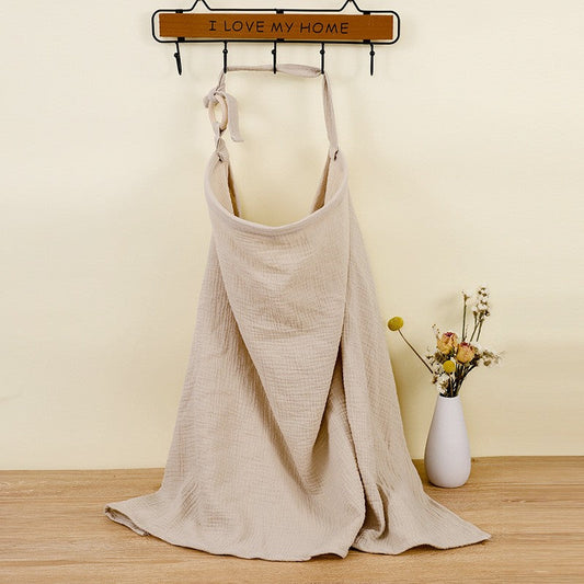Beiger Musselin-Babyhandtuch auf Holzständer, dekorative Blumen, weicher Stoff, Badezimmerdekor.