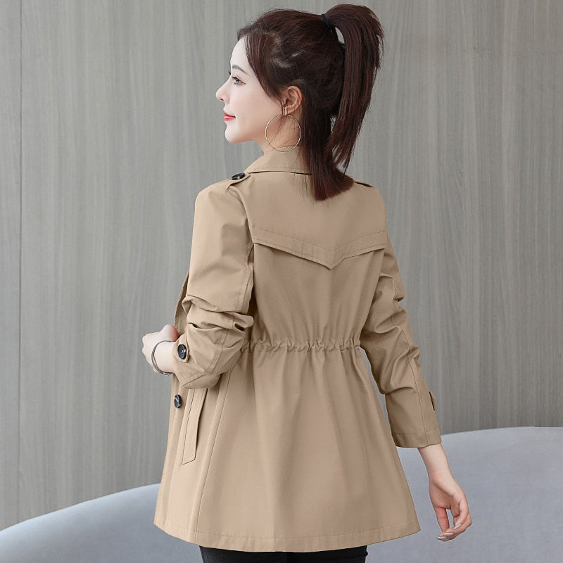 Frau in beige Trenchcoat, Rückansicht, eleganter Damenmantel, Herbstmode, stilvoll, modern.