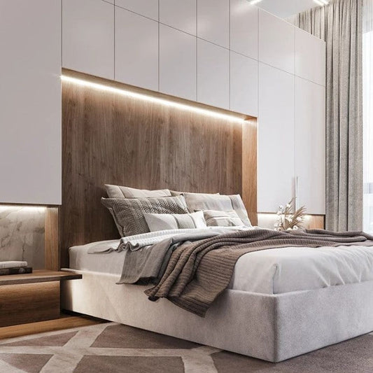 Modernes Schlafzimmer mit grauem Bett, Holzakzentwand, LED-Beleuchtung und beigen Vorhängen.