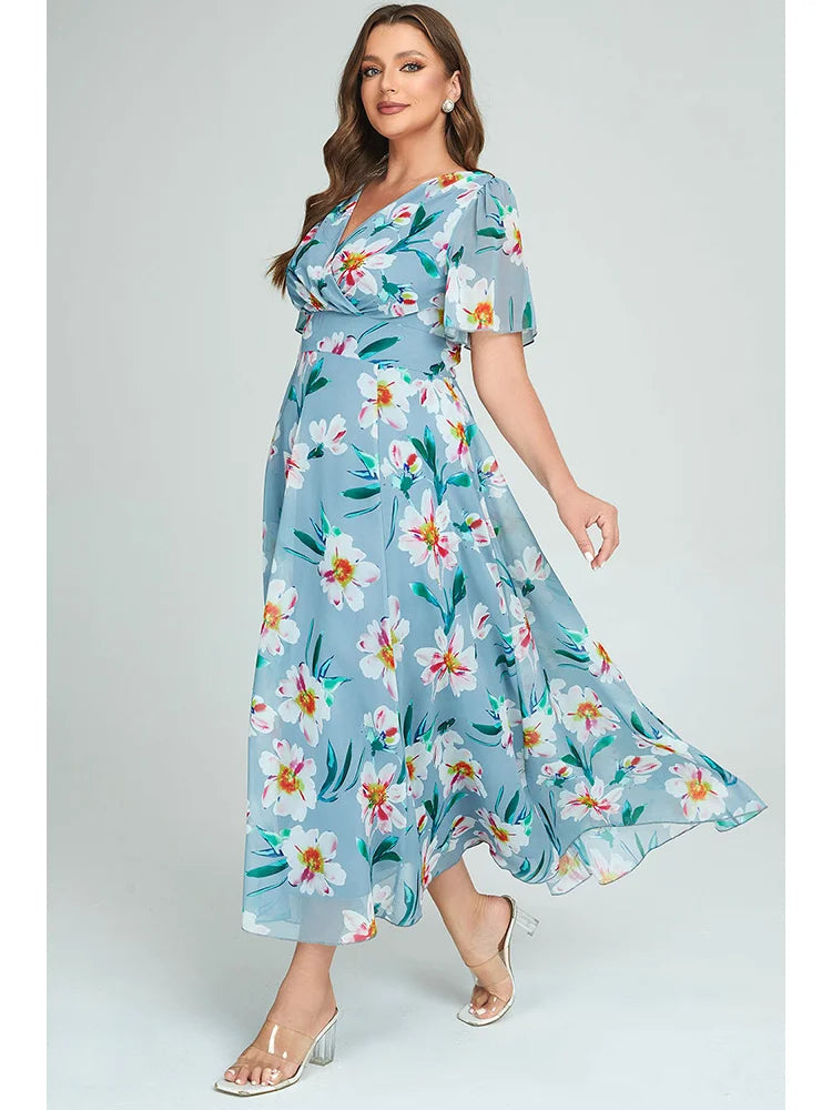 Frau in blauem, geblümtem Maxikleid mit transparenten Ärmeln, elegantes Sommeroutfit.