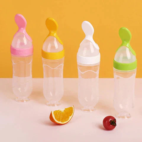 Vier bunte Babyflaschen mit Löffelaufsatz vor gelbem Hintergrund, transparentes Design.