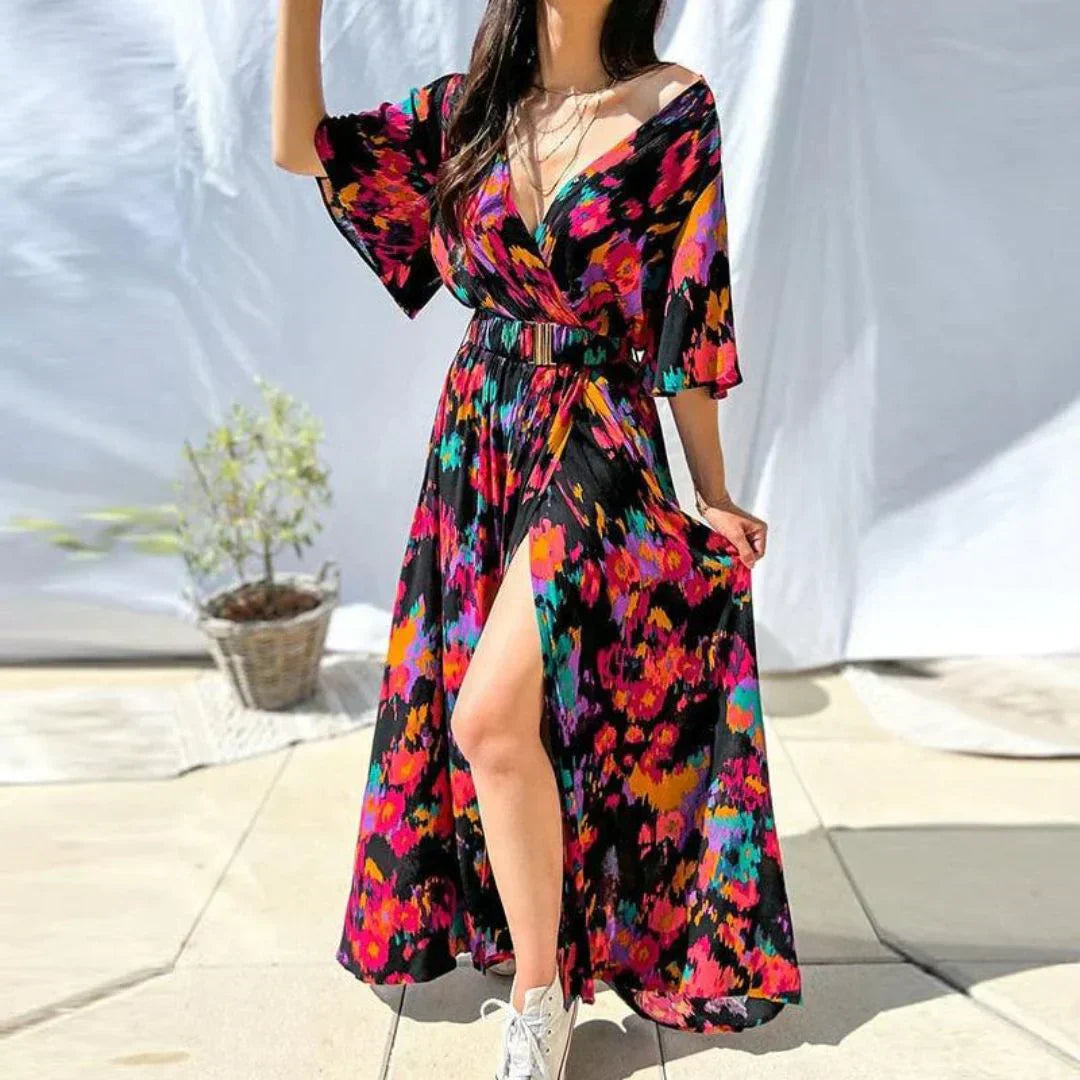 Frau in buntem Maxikleid mit Blumenmuster, V-Ausschnitt, Sommermode, draußen.