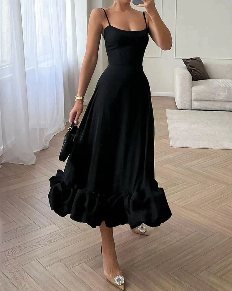 Frau in elegantem schwarzem Abendkleid mit Rüschen, modisch, stilvoll, Wohnzimmer.