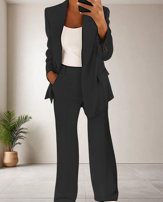Frau in schwarzem Anzug mit weißem Top, Businessmode, eleganter Look, moderne Damenbekleidung.