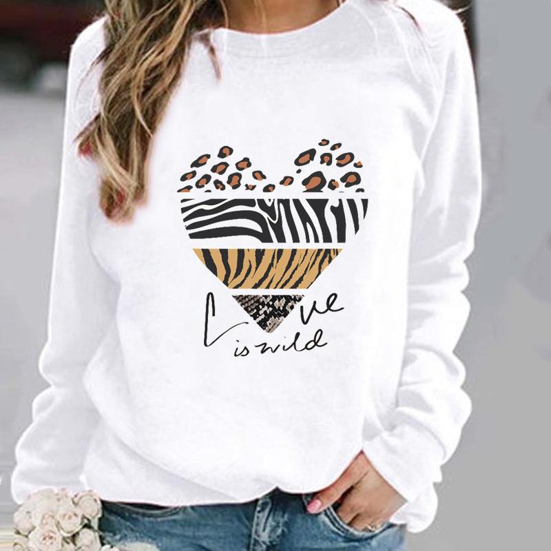 Frau trägt weißen Pullover mit Herzmotiv aus Tiermustern und Schriftzug "Love is wild".