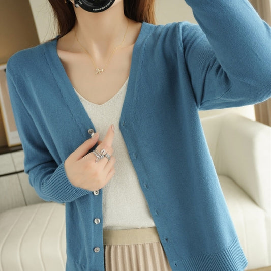 Frau trägt blauen Strick-Cardigan, V-Ausschnitt, Knöpfe, elegantes Design, Damenmode.