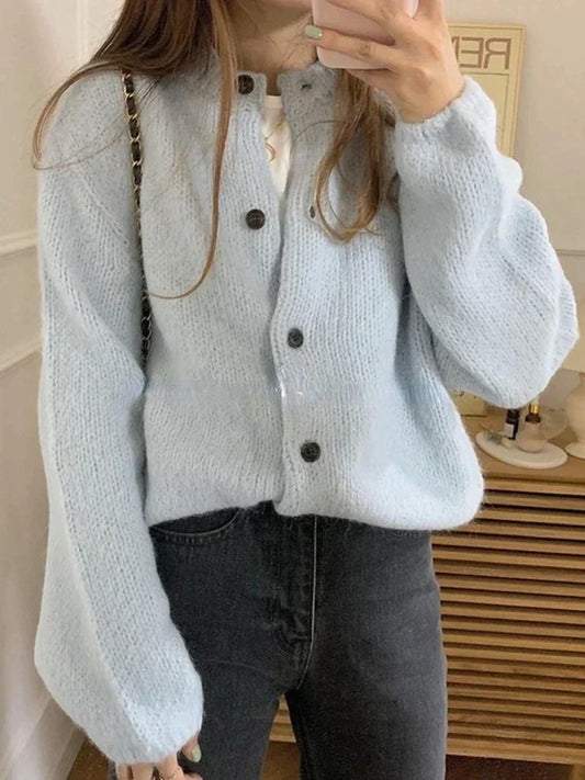 Frau in hellblauer Strickjacke mit Knöpfen, Oversize, Herbstmode, gemütlich, modisch.