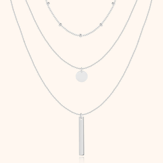 Silberne Halskette mit drei Lagen, Anhänger und Kugeldetails, eleganter Schmuck für Damen.