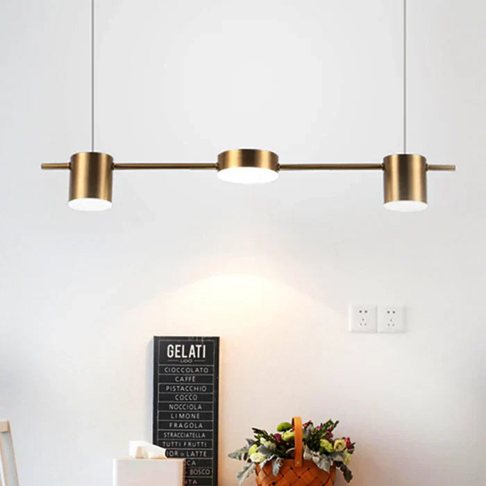 Moderne dreiflammige Pendelleuchte aus Messing über Esstisch, minimalistisch, stilvoll.