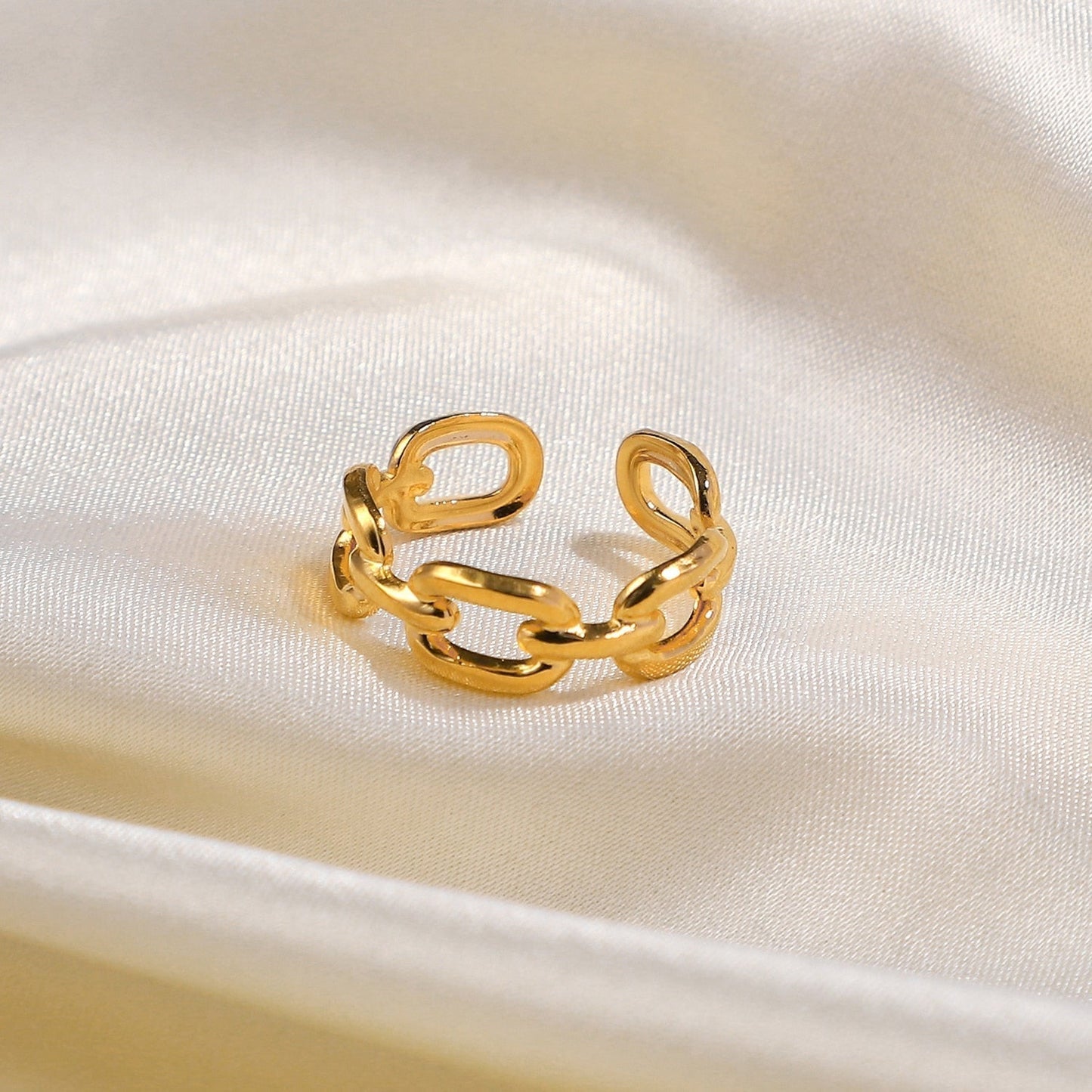 Goldener Kettenring auf Seidenstoff, verstellbar, modisches Schmuckstück, glänzend, elegant.