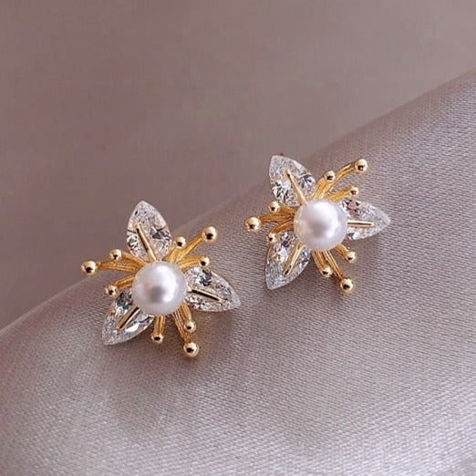 Goldene Ohrringe mit Perlen und Kristallen, elegantes Schmuckdesign, luxuriöses Accessoire.