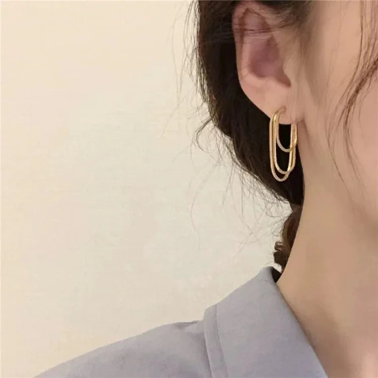 Goldene Creolen Ohrringe, doppelt, elegant, Damenmode, Schmuckaccessoire, Nahaufnahme.