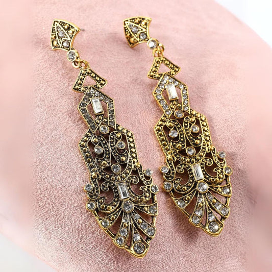 Goldene, verzierte Ohrringe mit Kristallen, Vintage-Stil, Schmuck, luxuriös, elegant.