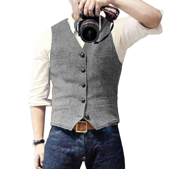 Mann mit grauer Weste, weißem Hemd, Jeans, hält Kamera. Herrenmode, Freizeitkleidung.