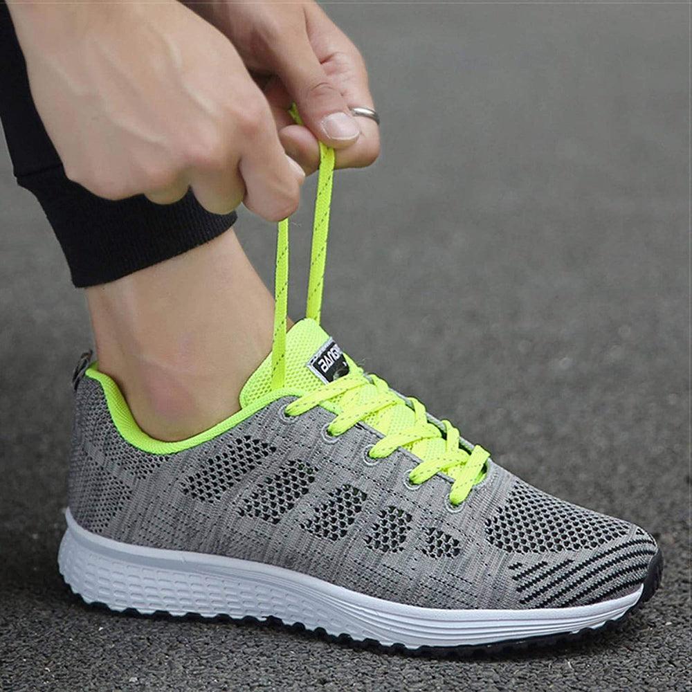 Grauer Sportschuh mit neongelben Schnürsenkeln, atmungsaktiv, ideal zum Laufen.