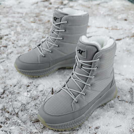 Graue Winterstiefel mit Schnürung, wasserdicht, gefüttert, auf schneebedecktem Boden.