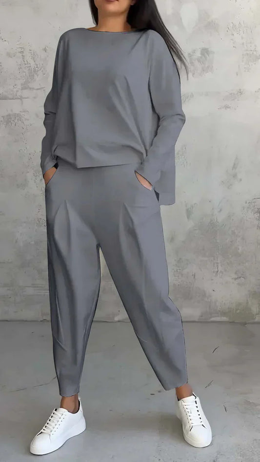 Damen-Outfit, grauer Oversize-Zweiteiler, lässig, mit weißen Sneakers, modisch, bequem.