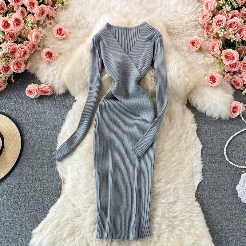 Graues geripptes Strickkleid, langärmelig, elegant, umgeben von rosa Rosen auf Teppich.