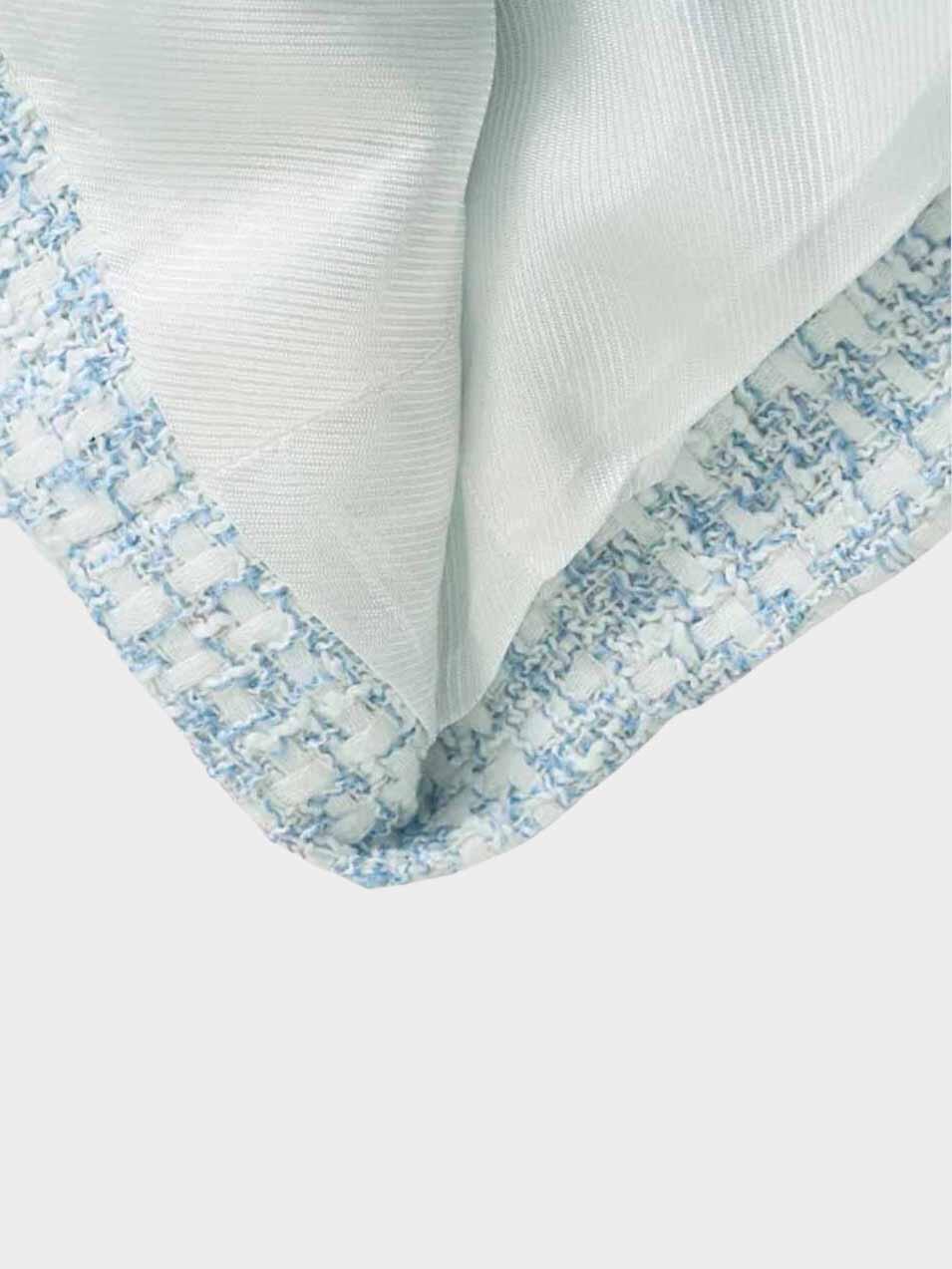 Nahaufnahme eines karierten Tweed-Blazers in Blau und Weiß, Stoffdetail, modisch, elegant.